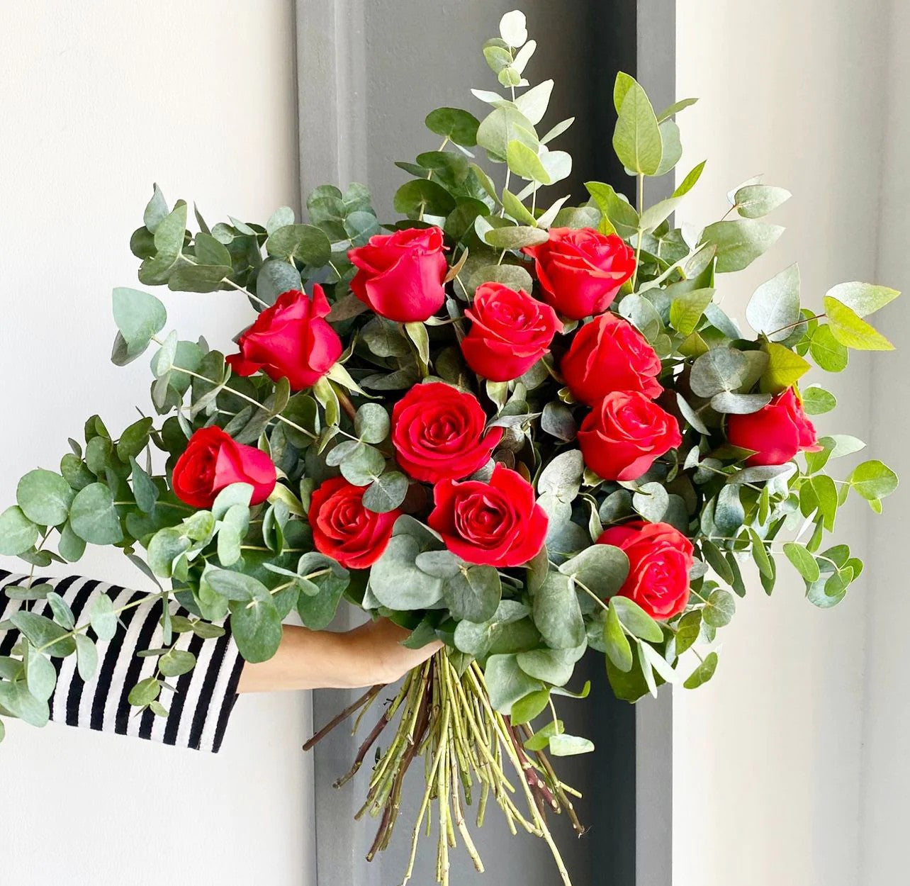 Experience the timeless allure of our handcrafted bouquet featuring luscious red roses and aromatic eucalyptus. Each stem meticulously selected and arranged to convey love and sophistication. Elevate any moment with the captivating beauty and delicate fragrance of this stunning floral arrangement, perfect for expressing heartfelt emotions or adding a touch of elegance to any space.