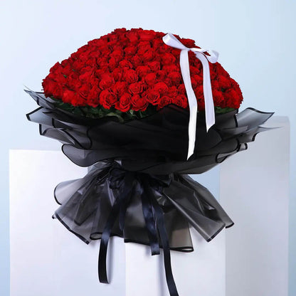 Our captivating bunch of red roses elegantly wrapped in a sleek black wrap symbolize love and passion. This stunning arrangement is a perfect gift to convey deep emotions and timeless elegance.